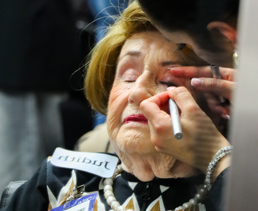 A survivor having her makeup done by a professional