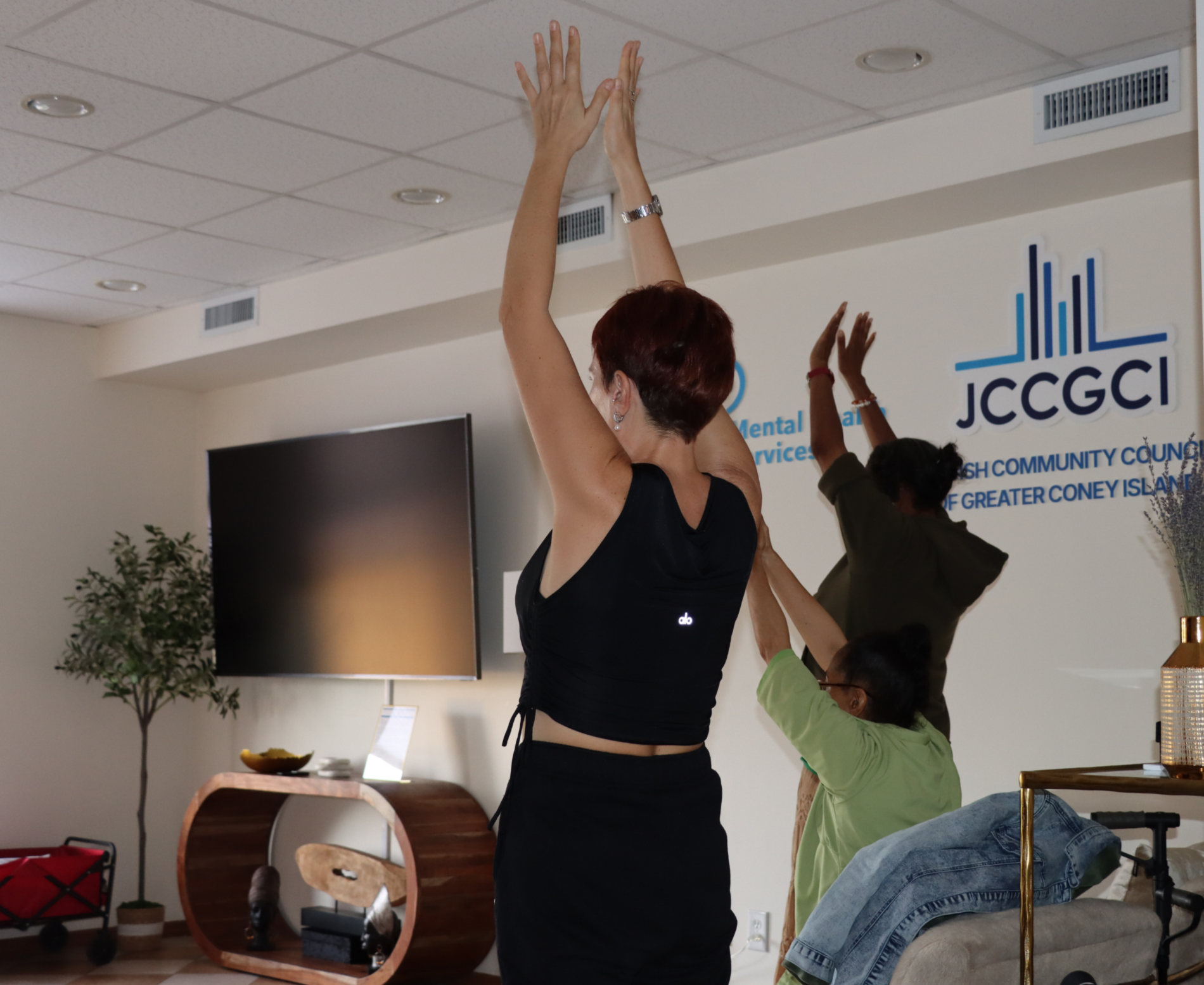 People following a yoga instructor at the TRC of JCCGCI