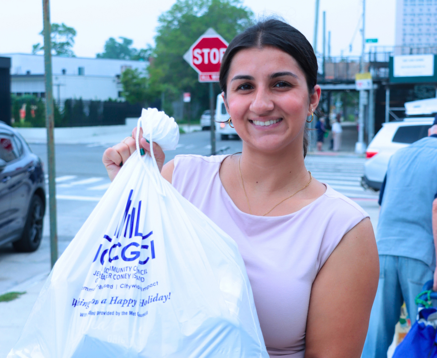 A volunteer with a JCCGCI food bag