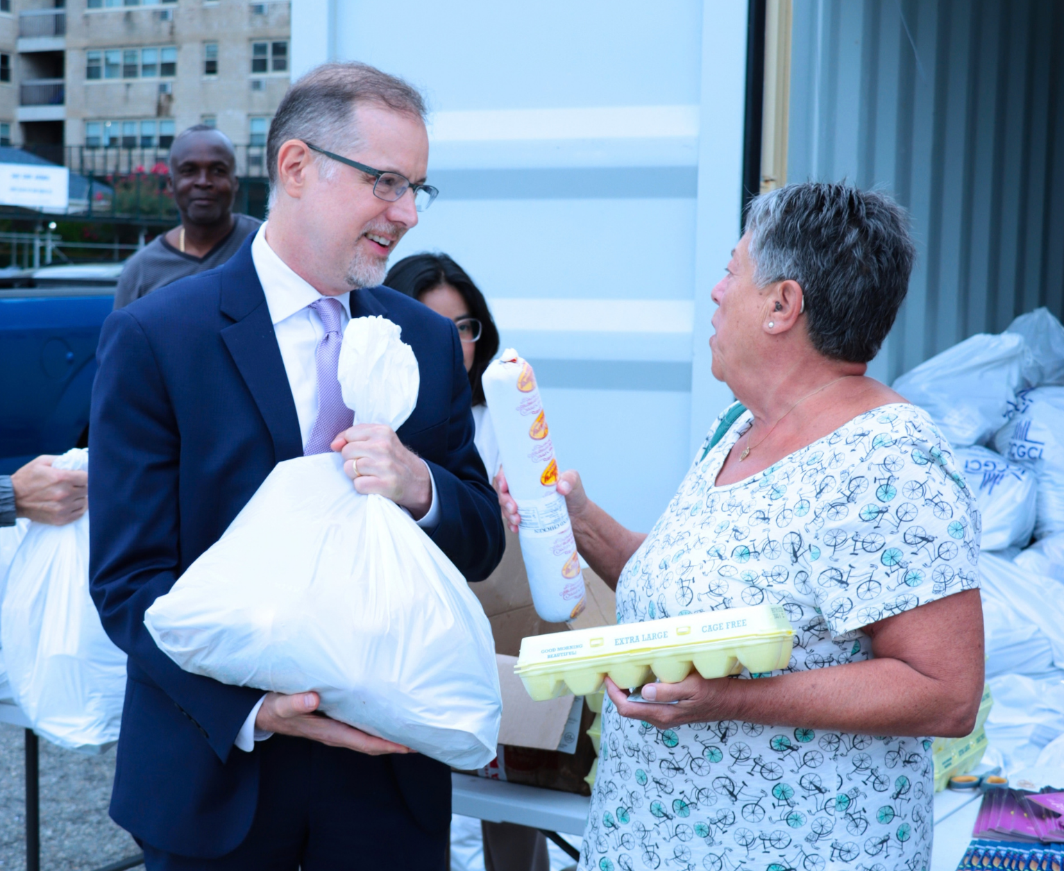 NYC Comptroller Mark Levine handing out a bag of food to an older adult