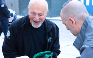 A volunteer handing food to an older adult client